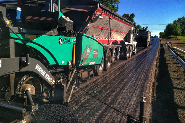 Asphalt being laid on a road by Karvo Paving Company's Asphalt Division